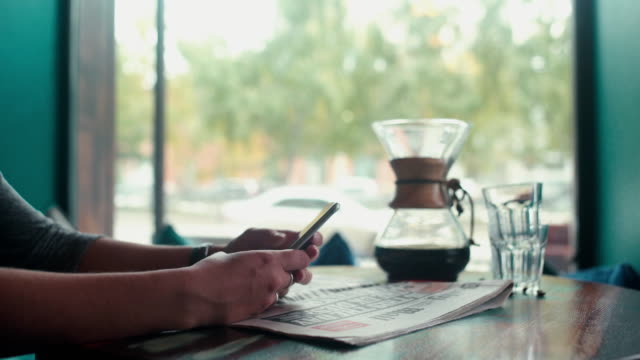 Nahaufnahme-von-weiblichen-Händen-drucken-Sms-auf-Ihrem-Mobiltelefon-in-einem-café
