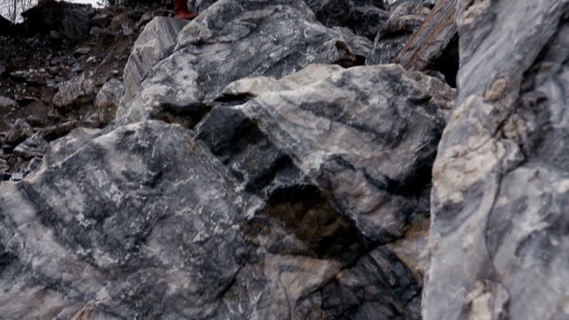 Porträt-eines-Mädchens-auf-den-Felsen-vor-Steinschlägen-Hintergrund.-Herbst-Kleidung.-Landschaft,-Weitwinkel