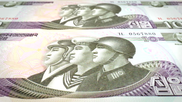 Banknotes-of-ten-wons-of-North-Korea-rolling,-cash-money,-loop