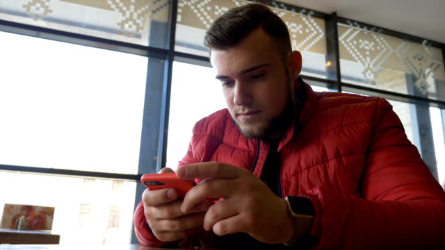 Teenager-durchsuchen-soziale-Medien-auf-einem-Smartphone-Touchscreen-und-nutzen-Smartwatch
