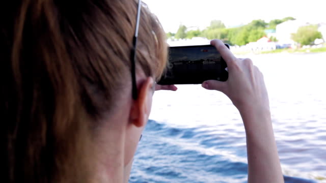 Chica-lanza-video-en-la-cámara-del-teléfono-durante-el-viaje-en-el-barco-en-el-río