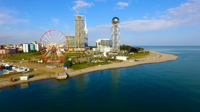 Batumi-landmarks-standing-at-seafront,-Ferris-wheel-and-Alphabetic-Tower-tourism