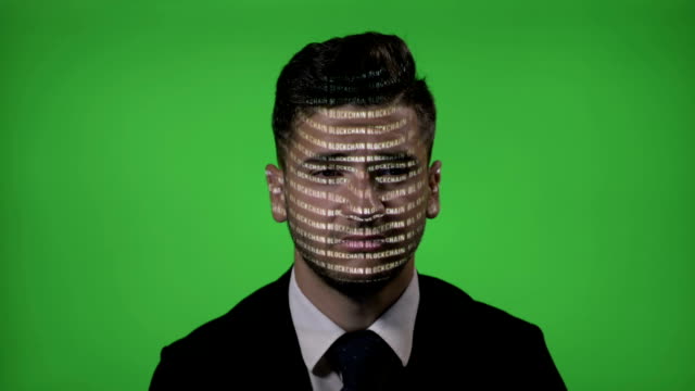 IT-businessman-at-work-with-projected-computer-blockchain-code-on-face-blinking-and-thinking-on-green-screen