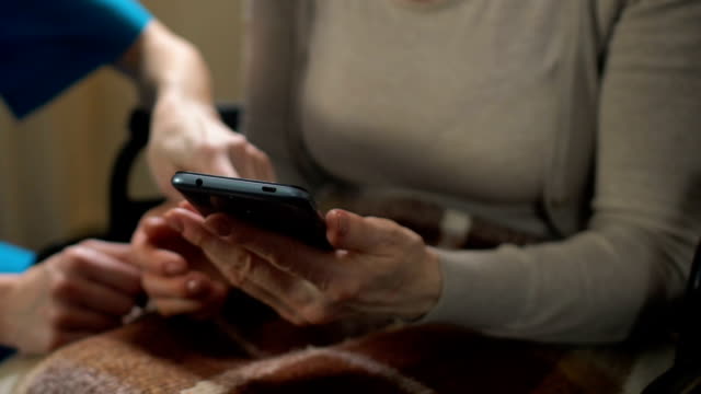 Krankenschwester-helfen-alte-Frau-mit-Behinderungen,-Online-shop-mit-mobilen-app