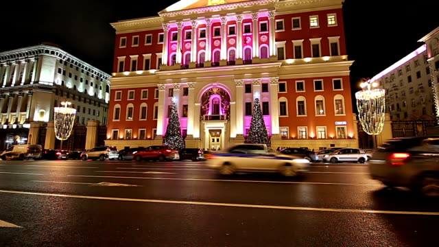 Christmas-and-New-Year-holidays-illumination-and-Traffic-of-cars--in-Moscow-city-center-and-Government-building-on-Tverskaya-street-at-night,-Russia