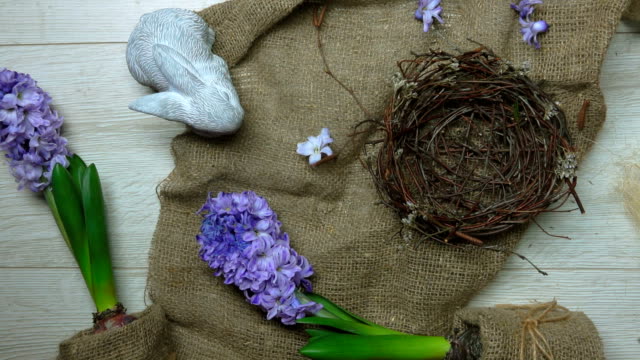 Hands-put-on-and-decorate-with-greenery-Easter-nest