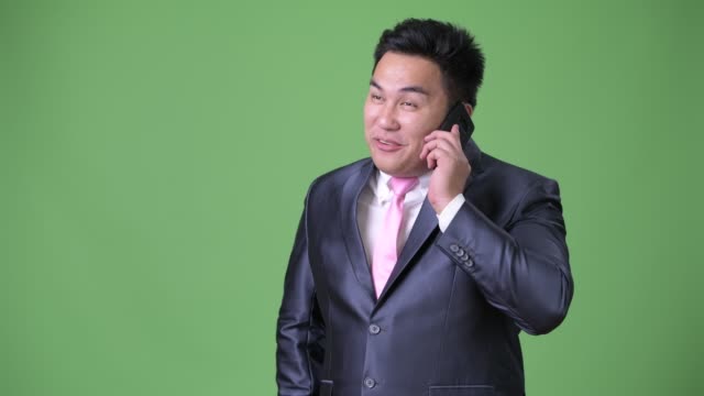 Joven-guapo-empresario-asiático-con-sobrepeso-sobre-fondo-verde
