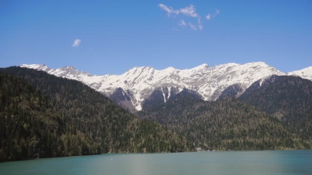 Aerial-panorama-of-mountainous-terrain-in-sunny-day,-over-huge-lake