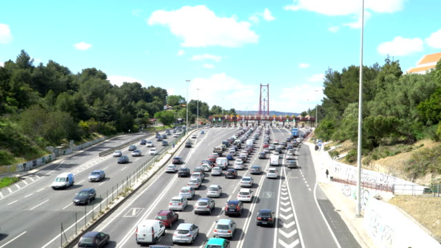 Pasando-por-el-punto-de-la-autopista-de-peaje,-estación-de-peaje-los-coches-cerca-del-puente.-Lisboa,-portugal
