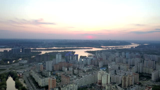 Aerial-Panoramavideo-aus-der-Drohne,-die-Darnyts'kyi-Bezirk,-Fluss-Dnjepr-mit-Brücken-in-der-Stadt-Kiew,-Ukraine-und-am-rechten-Ufer-des-Dnjepr-bei-Sonnenuntergang-im-Sommer.-FullHD-Video.