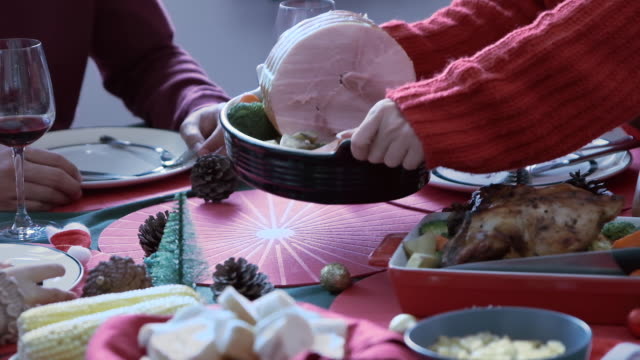 Mano-sosteniendo-tocino-grande-en-la-bandeja-colocada-en-la-mesa-para-la-cena-el-día-de-Navidad