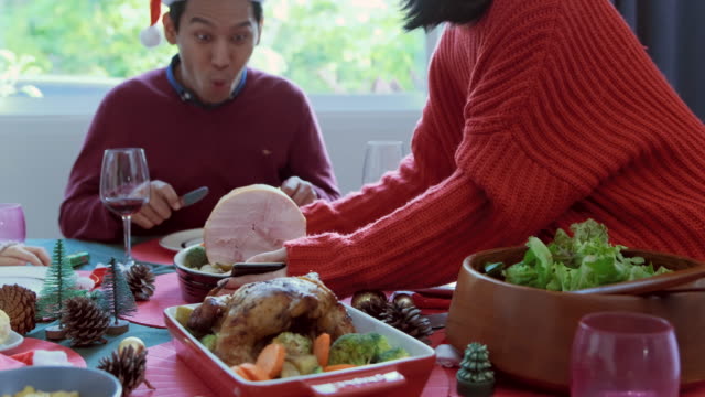 Asiatische-glückliche-Familie-mit-Mahlzeit-zusammen-im-Speisesaal,-der-mit-Weihnachtsbaum-geschmückt