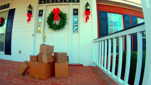 4k-wide-shot-of-Shipping-boxes-by-the-front-door-decorrated-for-the-holidays