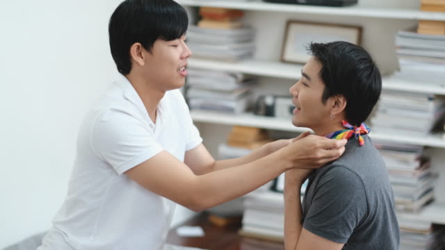 Un-gay-asiático-ayudar-al-otro-a-poner-bufanda-en-su-cuello-en-la-sala-de-libros
