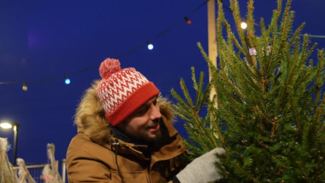 glücklicher-Mann-kauft-Weihnachtsbaum-auf-dem-Markt