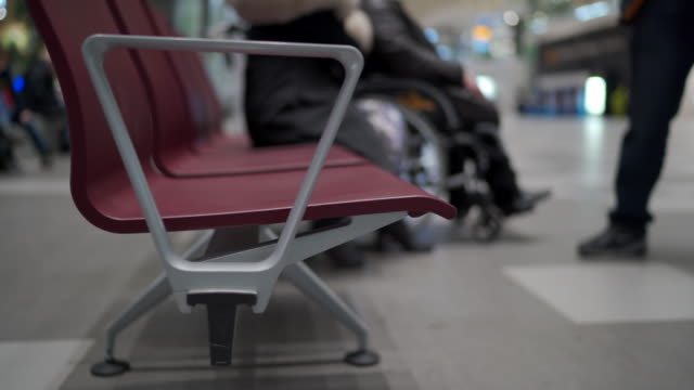 Mochila-de-viaje-en-el-banco-en-la-zona-de-espera-de-la-terminal-del-aeropuerto-con-sillas