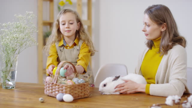 Happy-Girl-and-Woman-Petting-Bunny-en-Pascua