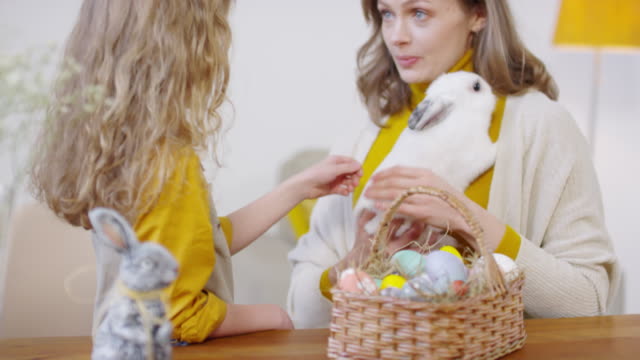 Mujer-y-niña-Petting-Bunny-en-Pascua