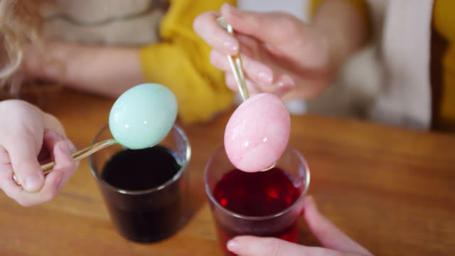 Hands-Holding-Dyed-Easter-Eggs-on-Spoons