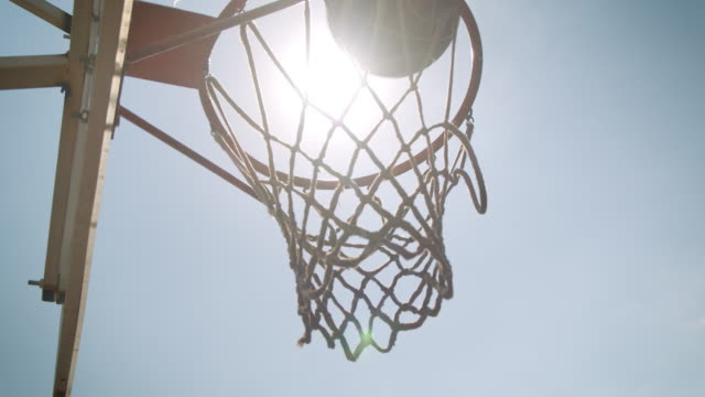 Closeup-portrait-of-basketball-ball-being-thrown-into-a-hoop-outdoors-on-the-court