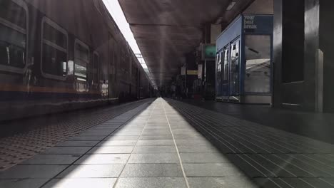 ROMA-/-ITALIA---25-DE-ABRIL-de-2019:-Timelapse-de-la-estación-de-tren-italiana-Termini-en-Roma.-La-gente-con-maletas-va-en-la-plataforma-cerca-del-tren.-Monitores-con-direcciones-de-tren,-relojes.-Día-soleado.