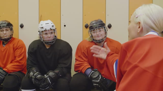 Female-Hockey-Players-Talking-in-Cloakroom