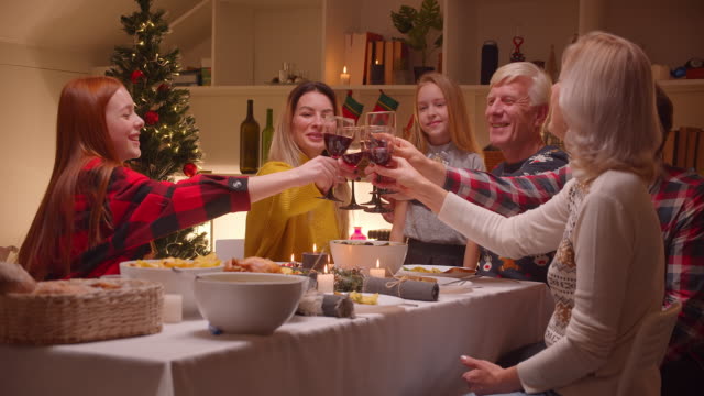 Große-Familie-Abendessen-Abend-Wein-Toast-Klinke-Gläser-Alkohol-Abendessen-Weihnachten-Wiedersehen-Weihnachten