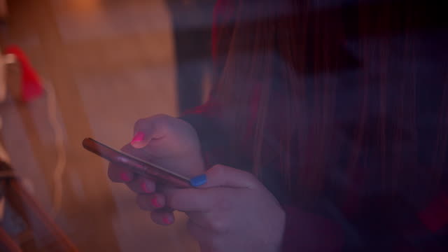 Rothaarige-Teenager-Mädchen-am-Fenster-verwendet-ein-Smartphone-Weihnachten-Reflexion-Coziness