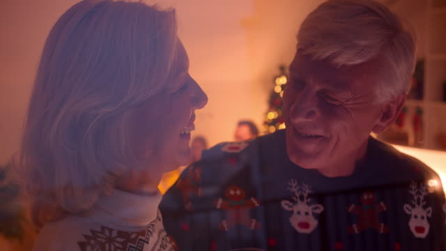 Älteres-Paar-umarmt-Küsse-Liebe-Weihnachten-hinter-Glas