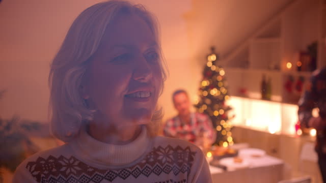 Großmutter-schaut-aus-dem-Fenster-Weihnachten-Familienabend-hinter-Glas-gemütlich