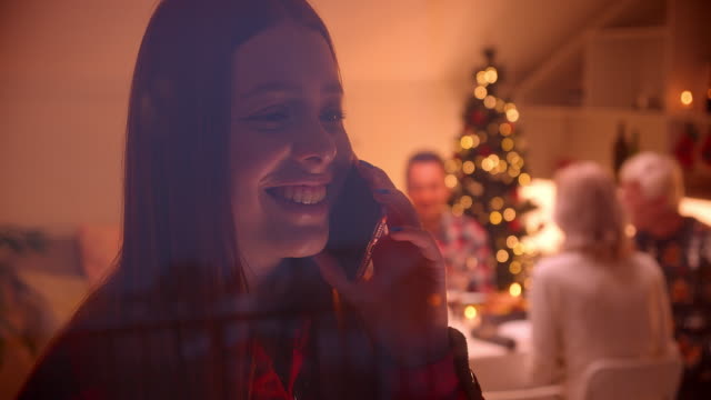 Teen-redhead-Mädchen-sprechen-Smartphone-lächelnd-Weihnachten-hinter-Glas