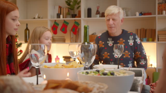 Familie-sitzt-am-Tisch-Weihnachten-Großvater-Kopf-der-Enkelin-Familie-Rotschopf-Mädchen