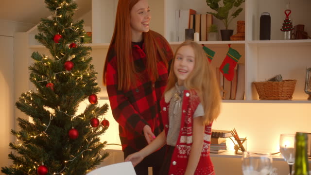 Sisters-decorate-the-Christmas-tree-grandchildren-hug-grandparents-family