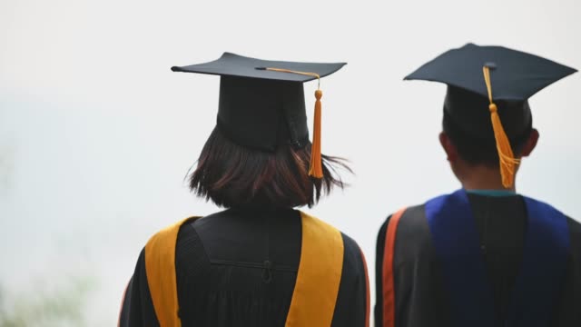 Asiatische-Studenten-trugen-am-Abschlusstag-schwarze-Rüschenanzüge,-schwarze-Hüte,-gelbe-Quasten.