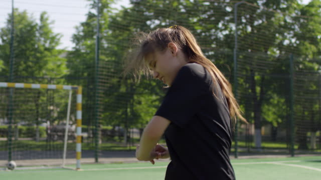 Junges-Mädchen-macht-Stretching-Übung-vor-dem-Fußballtraining