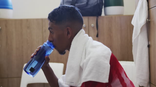 Soccer-player-drinking-water-in-the-locker-room