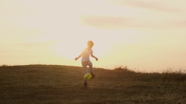 Junge-läuft-nach-Fußball--Outdoor-Freizeit.-Himmel-und-Horizont.