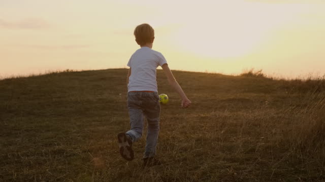 Junge-läuft-nach-Fußball--Outdoor-Freizeit.-Himmel-und-Horizont.
