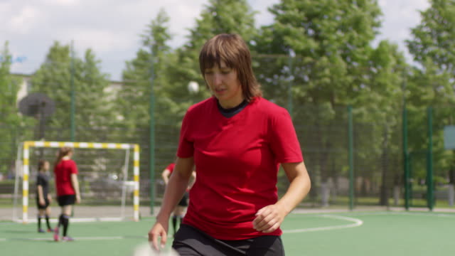 Junge-Fußballerin-jongliert-Ball-und-lächelt-vor-der-Kamera