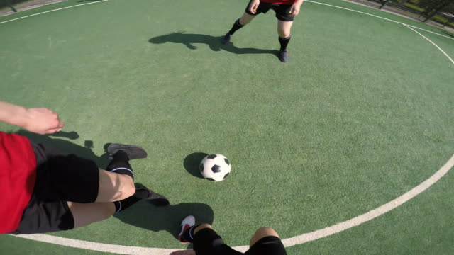 POV-de-mujer-jugando-al-fútbol-en-el-campo-verde
