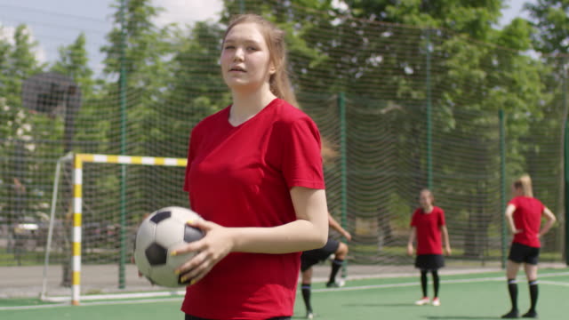 Junge-Sportlerin-Jonglieren-Fußball-und-posiert-für-Kamera