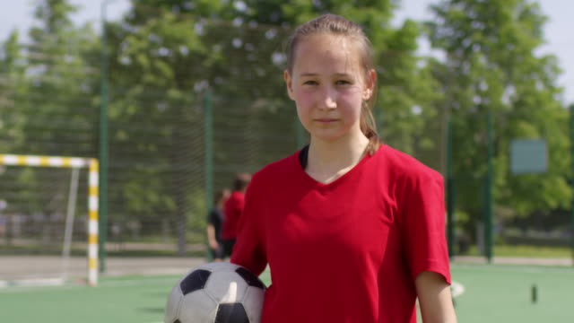 Junge-Fußball-Mädchen-Holding-Ball-und-posiert-für-Kamera