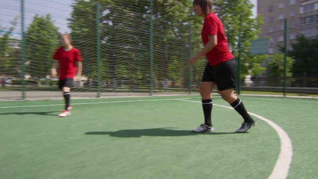 Junge-Frauen,-die-auf-green-field-Fußball-spielen