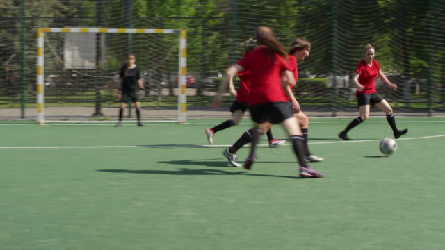 Junge-Sportlerinnen-spielen-Fußball-auf-dem-Außenfeld