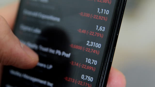 Global-economic-crisis.-World-market-decline.-Negative-stock-quotes-and-other-debt-securities-on-the-stock-market.-Shot-of-Checking-stock-quotes-on-mobile-phone