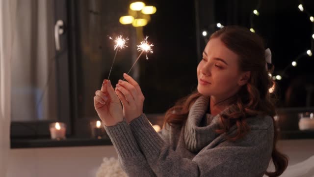 happy-young-woman-with-sparklers-at-home