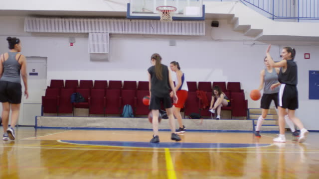 Jóvenes-Atletas-Femeninas-Practicando-Disparar-Baloncesto-en-El-Aro