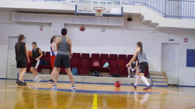 Professionelle-Spielerinnen-üben-Schießen-Basketball-in-Reifen