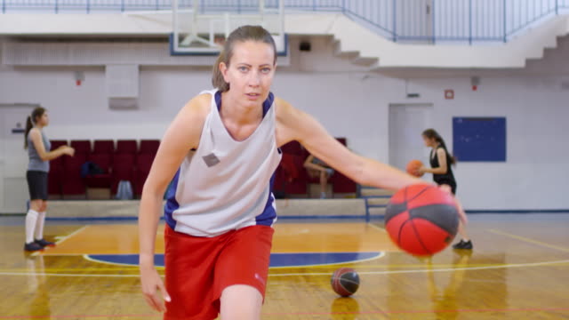 Atleta-Femenina-realizando-trucos-de-regate-de-baloncesto-en-la-cancha