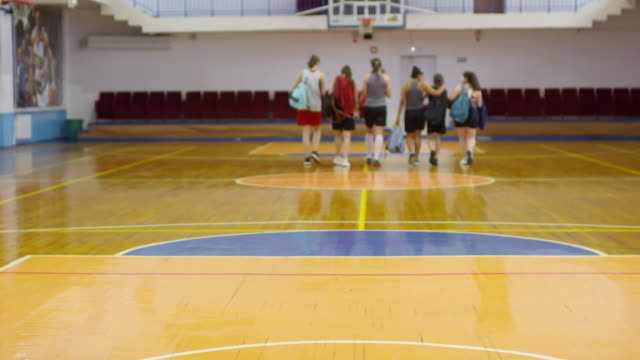 Equipo-de-jugadoras-de-baloncesto-femeninas-que-salen-de-la-cancha-cubierta